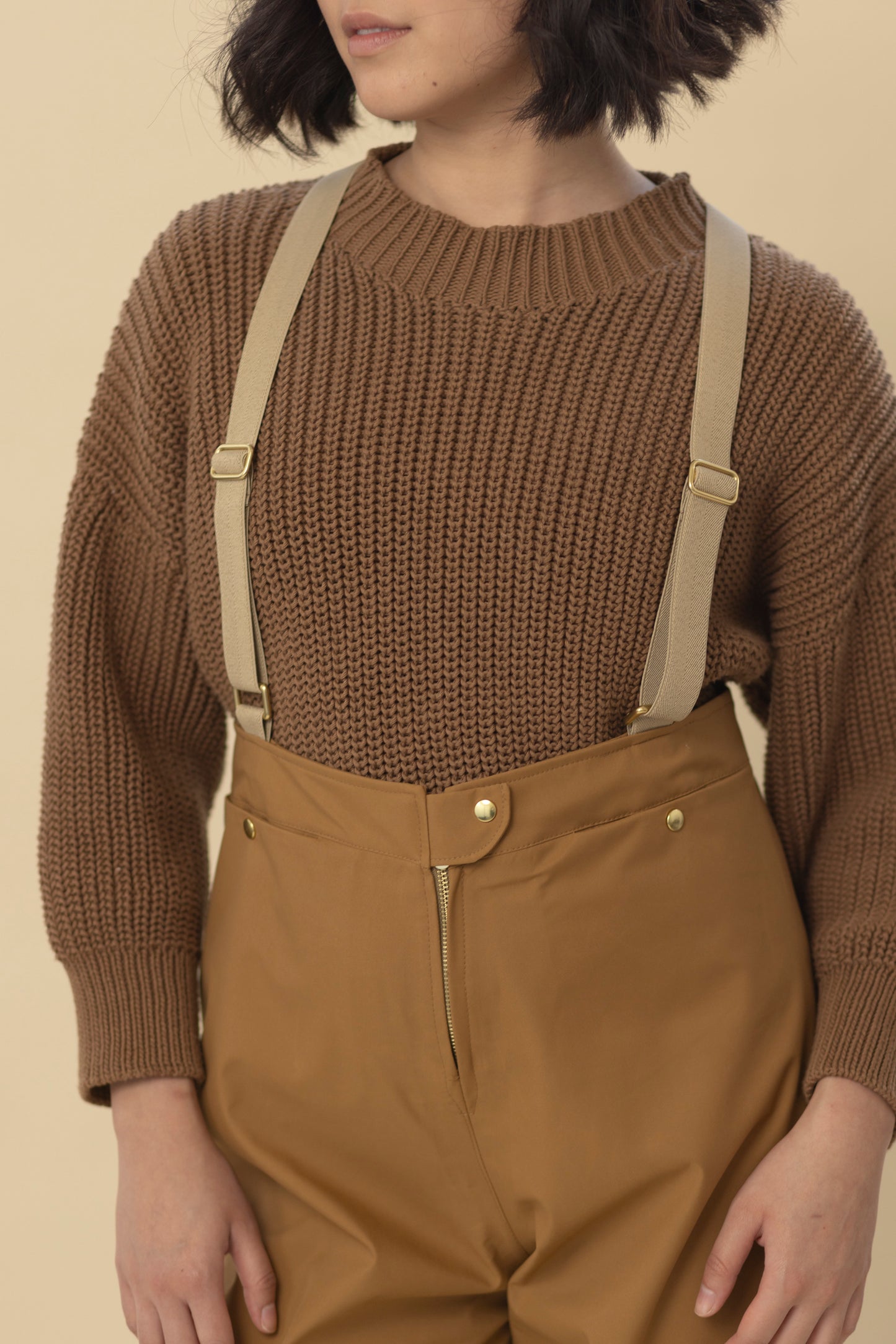 Close-up of hidden front pocket with snap closure on waterproof pants