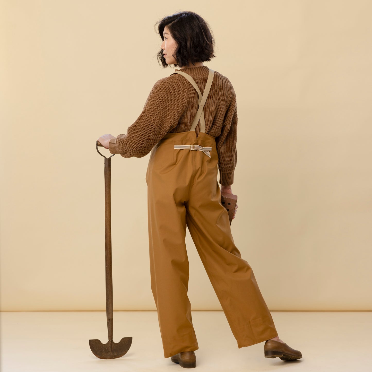 Back view of bark rain pants showing adjustable strap and high waist fit