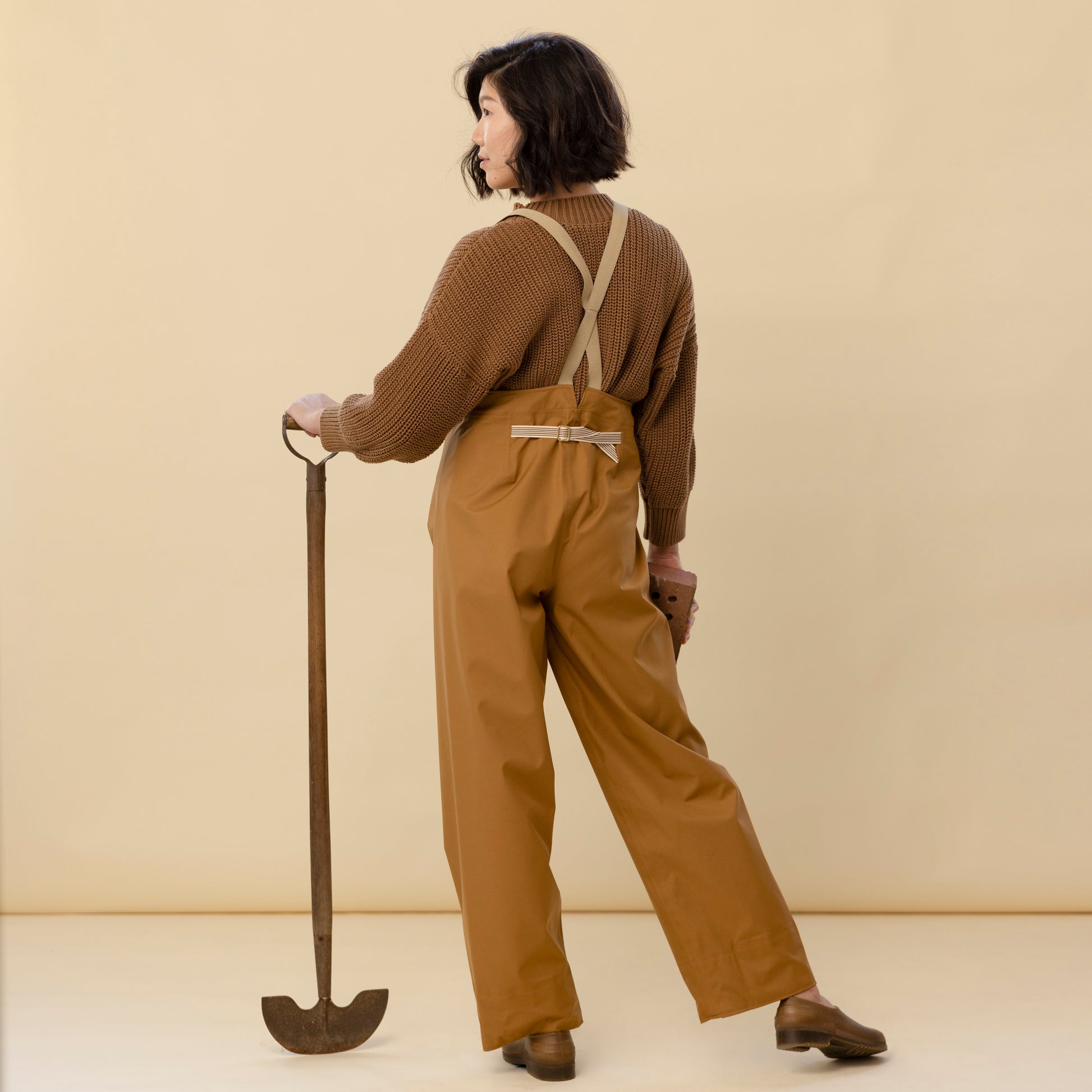 Back view of bark rain pants showing adjustable strap and high waist fit